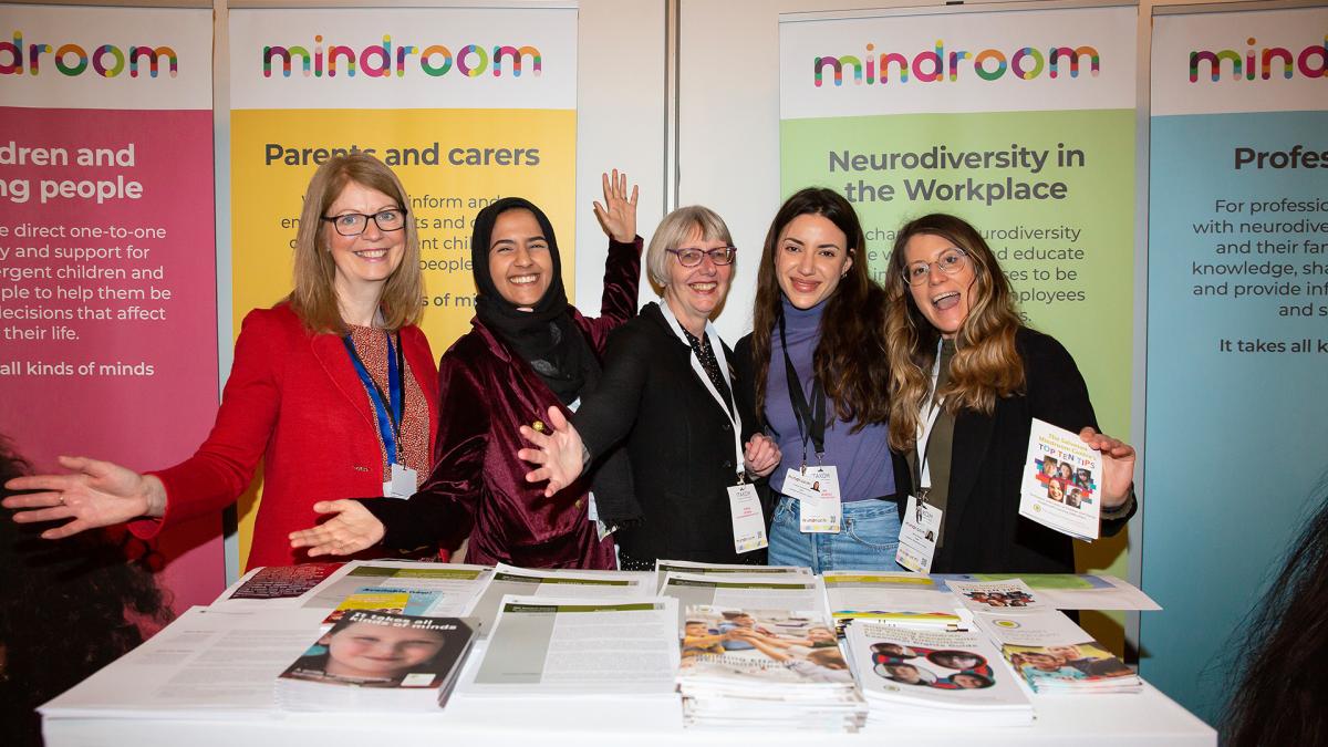 photo of 5 members of Mindroom team standing in front of posters and behind table of leaflets