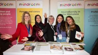 photo of 5 members of Mindroom team standing in front of posters and behind table of leaflets