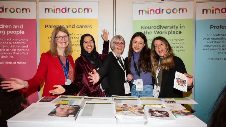 photo of 5 members of Mindroom team standing in front of posters and behind table of leaflets