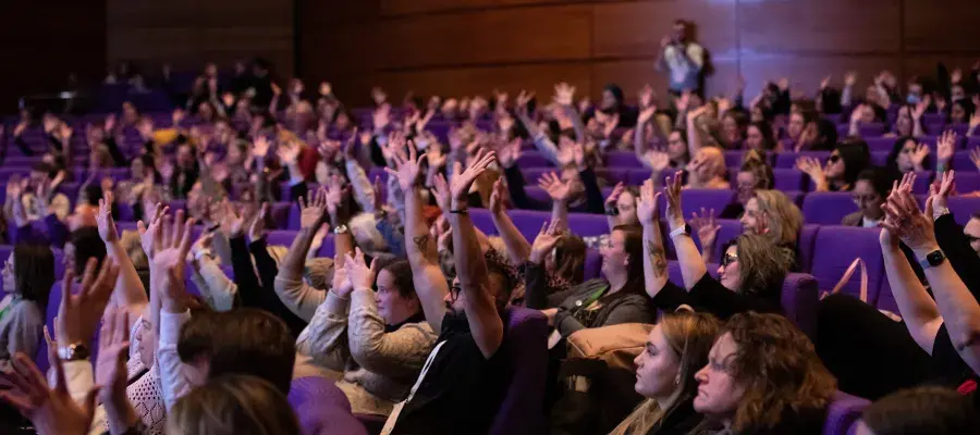 photo of seated delegates waving hands in the air
