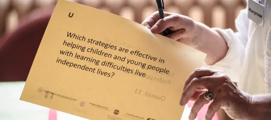 Someone holding a research question on a sheet of paper