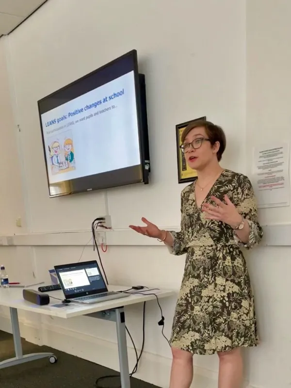Alyssa Alcorn standing in front of a large screen, speaking to an audience, not shown in the photo