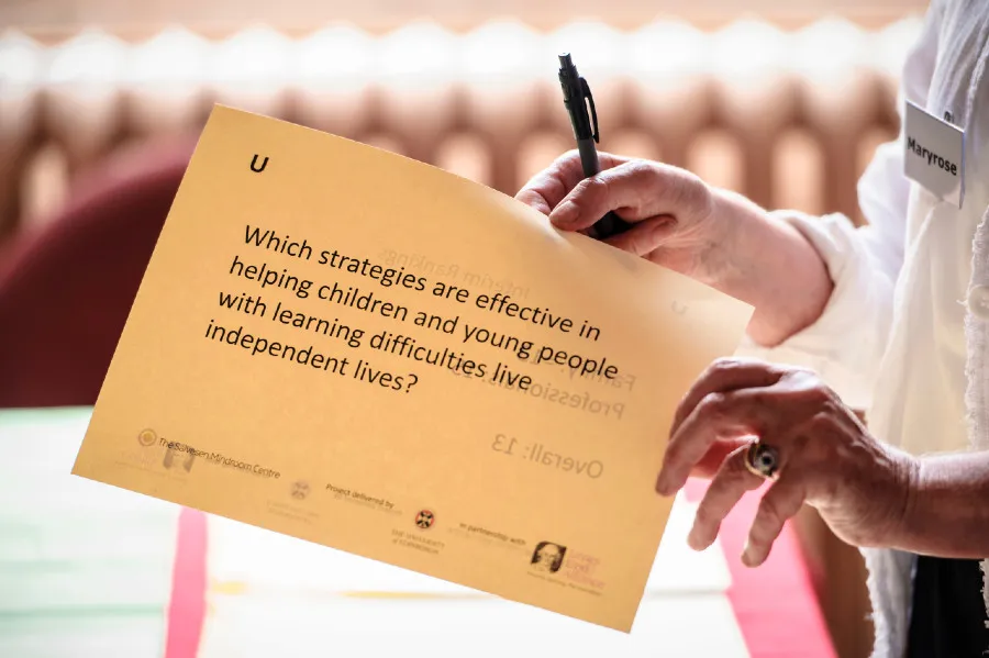 Someone holding a research question on a sheet of paper