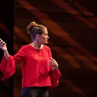 Photo of lady delivering lecture pointing to screen (out of shot)