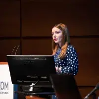 Photo of female speaker standing at lecturn 