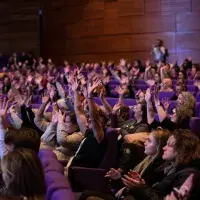 photo of seated audience all waving
