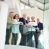Photo of 6 adults lined up for photo shot on balcony