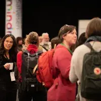 Photo of crowd of people chatting in small groups