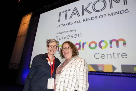 Photo of two ladies standing in front of screen displaying ITAKOM logo and Salvesen Mindroom Centre logo