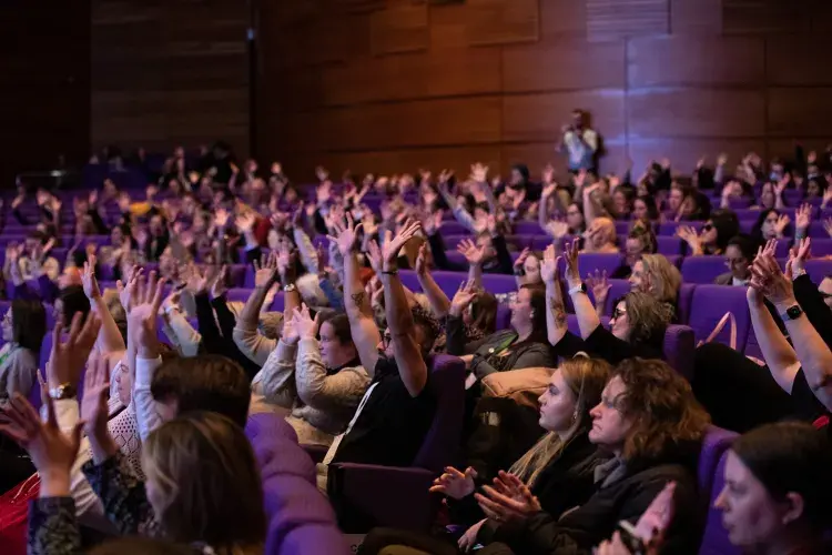 photo of seated audience all waving