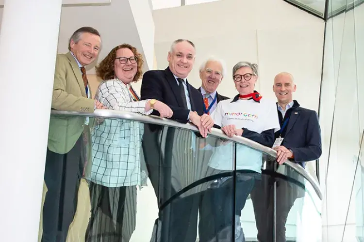 Photo of 6 adults lined up for photo shot on balcony
