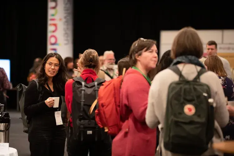 Photo of crowd of people chatting in small groups