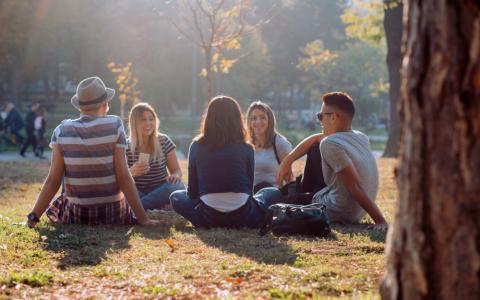 group of teens relaxing in park